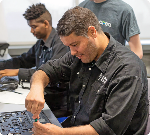 Image representing a member of the OPEQ team working on repairing a laptop computer