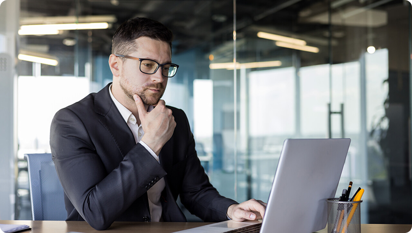 Image représentant un homme d’affaires qui lit un document en ligne avec attention